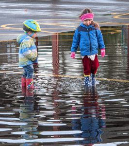 Kids playing in water puddle